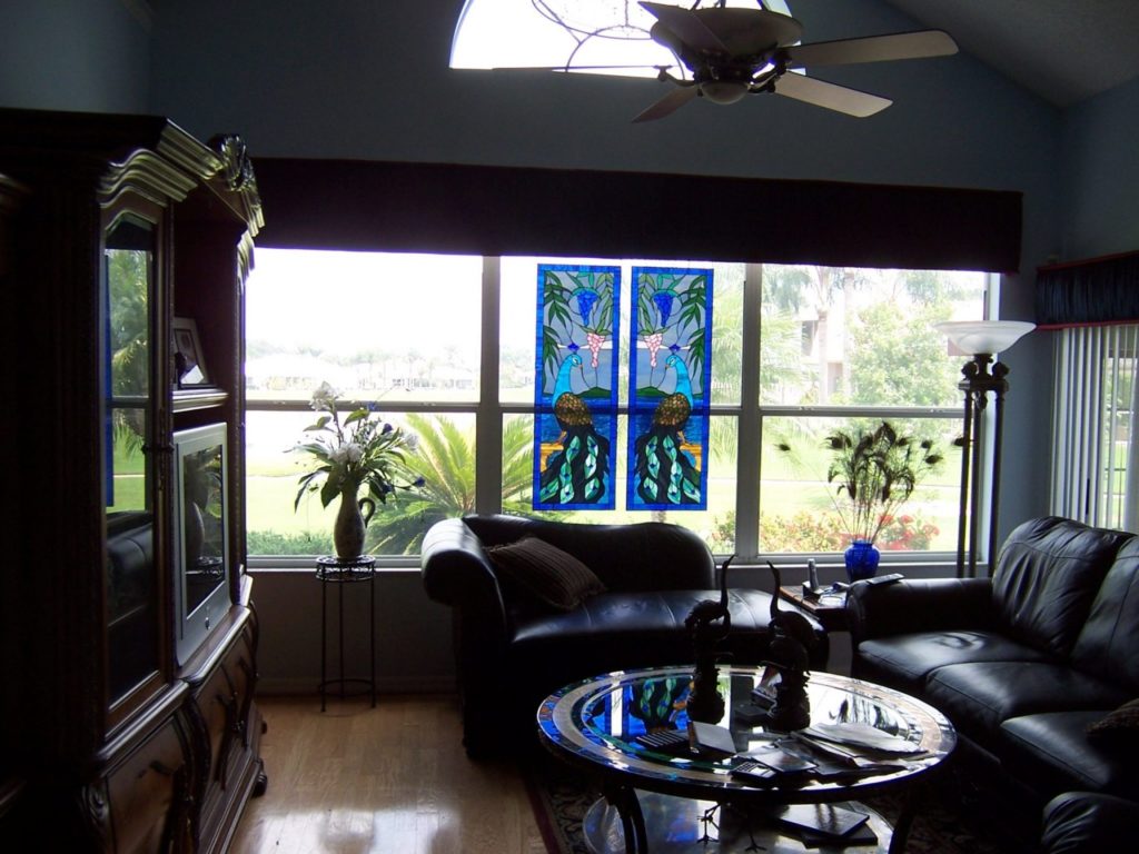 Pair of peacock stained glass windows suspended by hooks & chains
