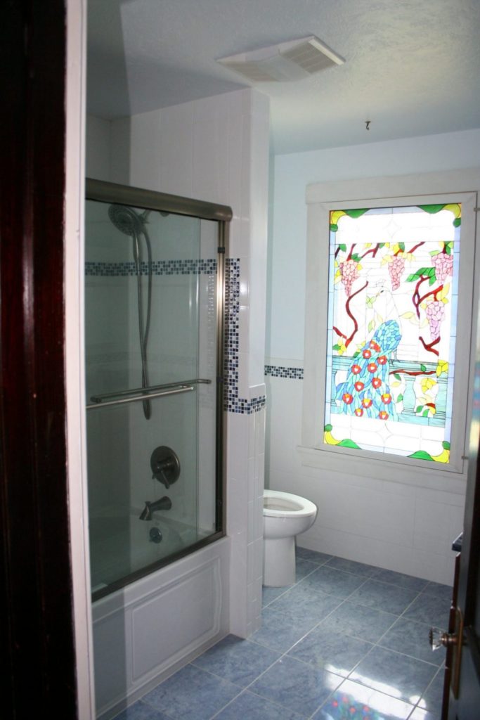 Colorful Peacock Stained Glass Window Installed Into A Bathroom