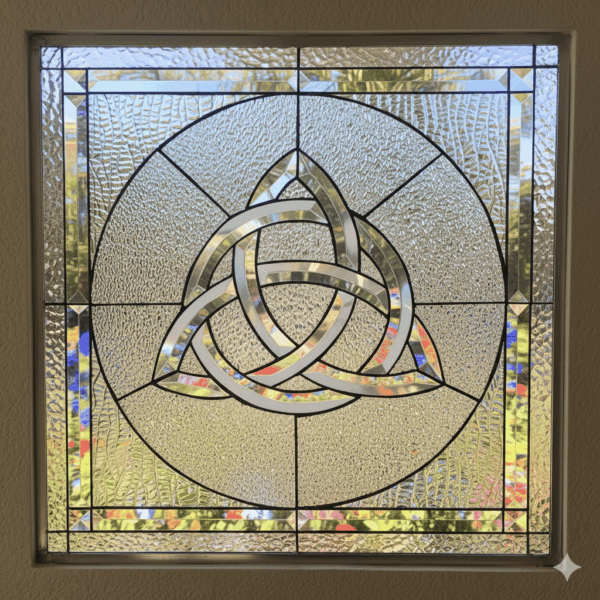 A square stained glass window with a large, beveled glass Celtic Trinity Knot in the center. The knot and the outer border are made of sparkling, clear beveled glass, set against a clear, textured privacy glass background.