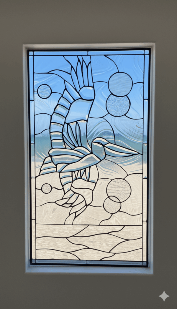 A rectangular leaded glass window panel depicting a stylized pelican in flight over a beach. The entire coastal scene is rendered in various types of clear, textured, and beveled glass, with the background featuring abstract circular shapes.