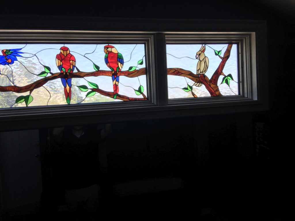 Stained Glass Parrot Gathering Windows Installed In A Bathroom