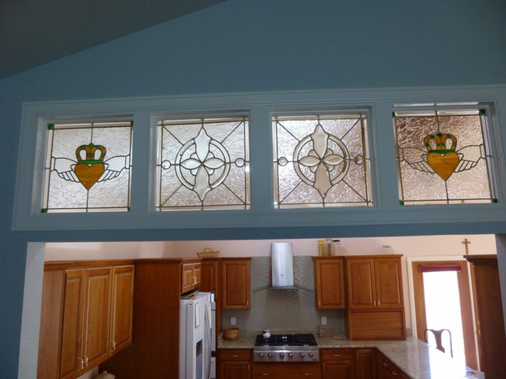 Four decorative pineapple & beveled transom stained glass windows above a set of french doors