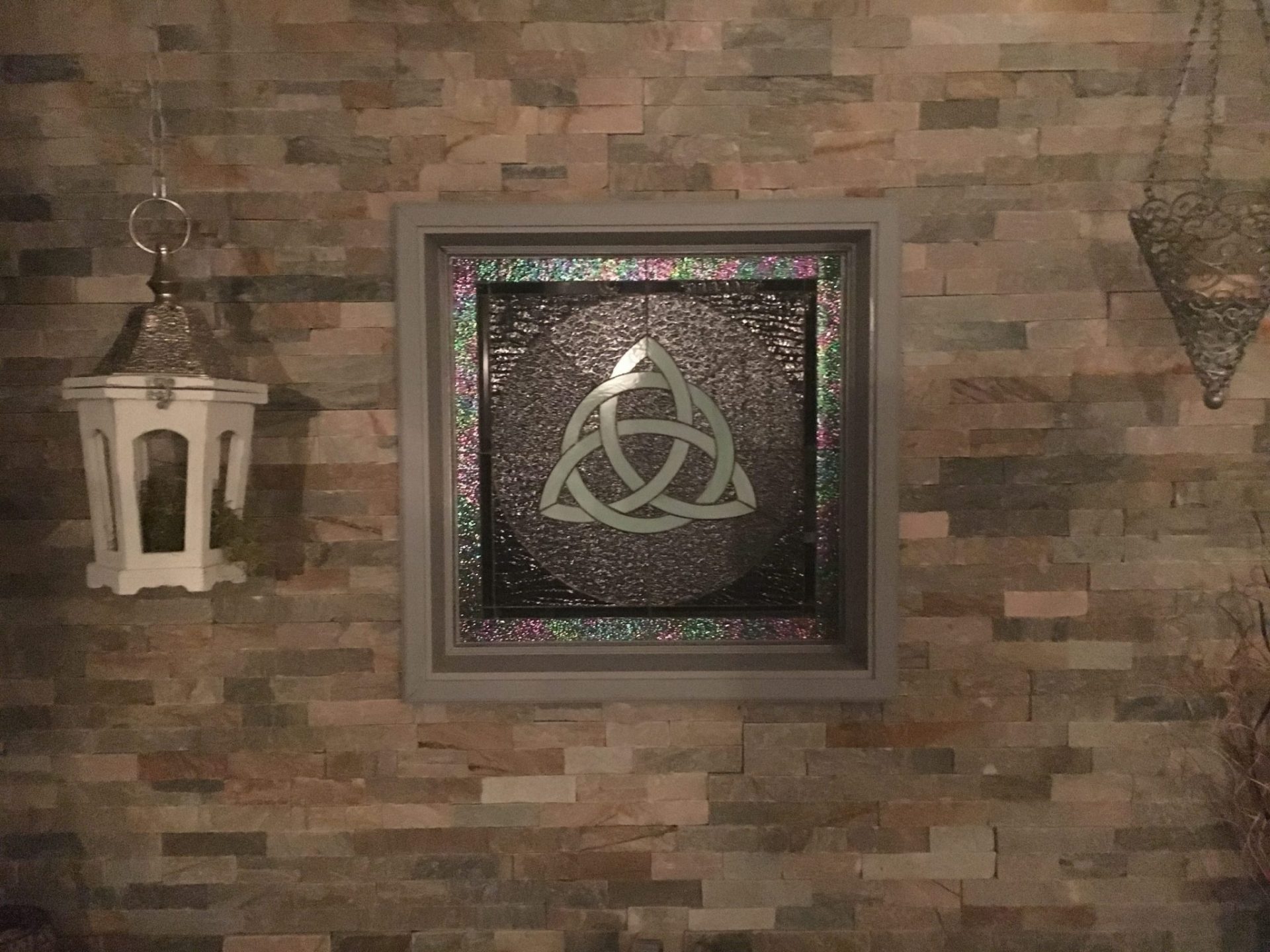 Celtic Knot Stained Glass Window Installed In A Brick Wall For Added Character