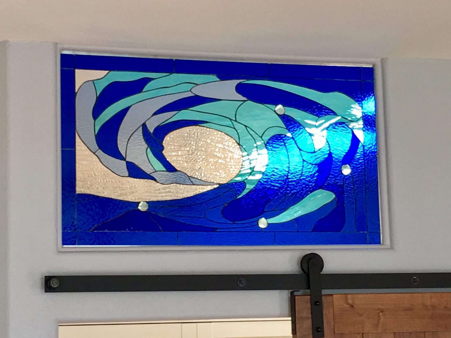 Cresting Wave Stained Glass Insert Installed Above A Sliding Barn Door