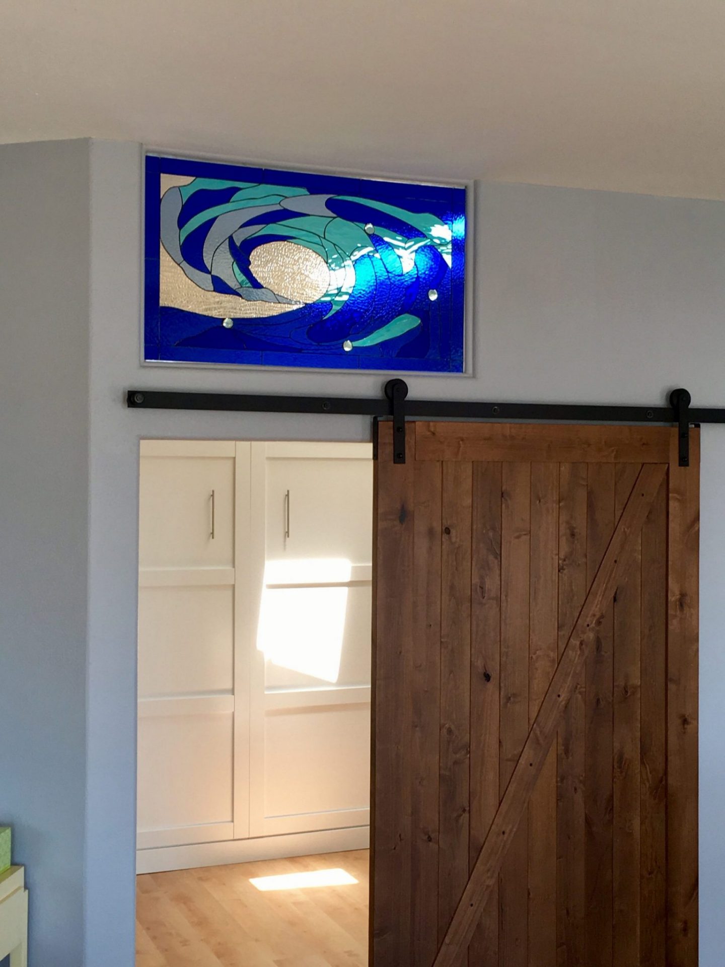 Cresting Wave Stained Glass Insert Installed Above A Sliding Barn Door