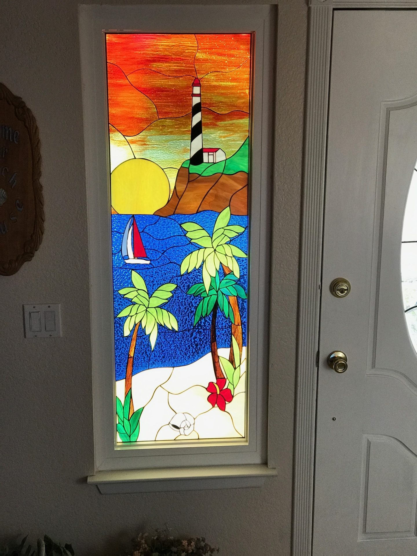 Lighthouse, palm tree and sunset stained glass side lite window added beauty and natural light