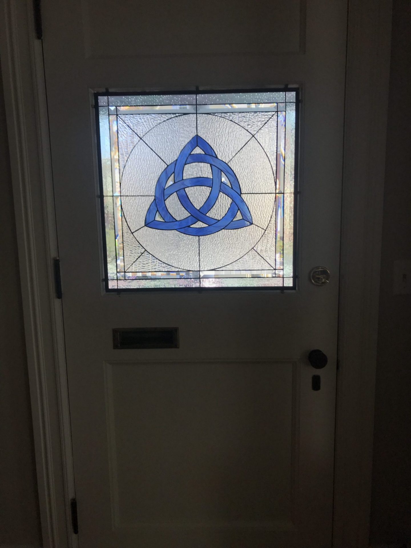 Single pane Celtic Knot stained glass inserted into a door with mirror clips