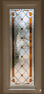A tall, rectangular stained glass panel featuring a clear textured glass diamond grid with amber round jewels, flanked by vertical amber and clear textured glass strips, and decorative clear scrollwork in top and bottom corners, set in a white frame.