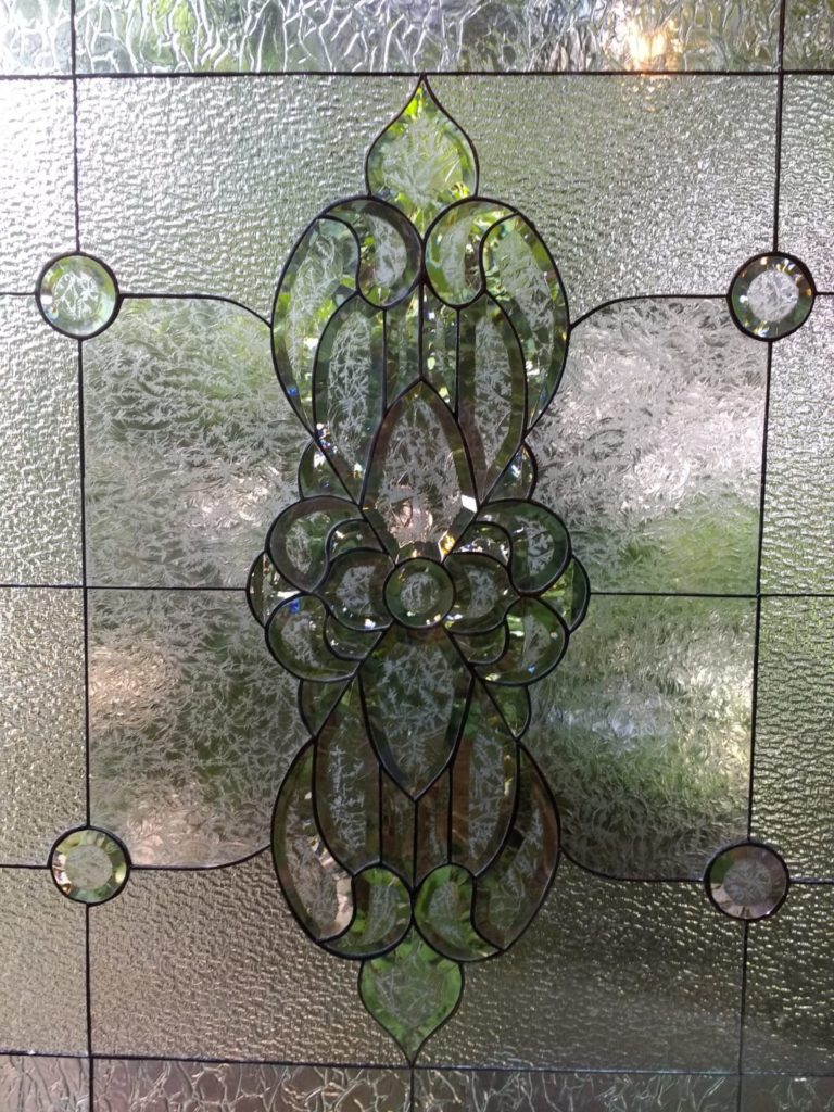 Magnificent beveled and clear textured glass window in master bathroom