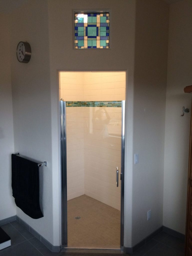 Transom window installed in between a bathroom and shower area for added decor