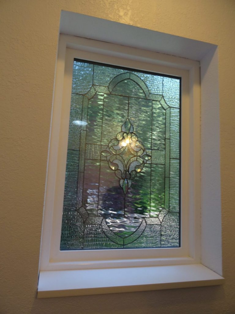 A beveled leaded artglass window installed over bathtub
