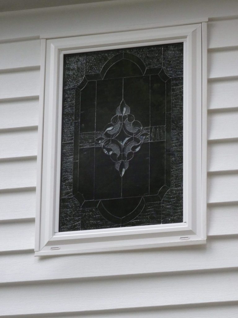 A beveled leaded artglass window installed over bathtub