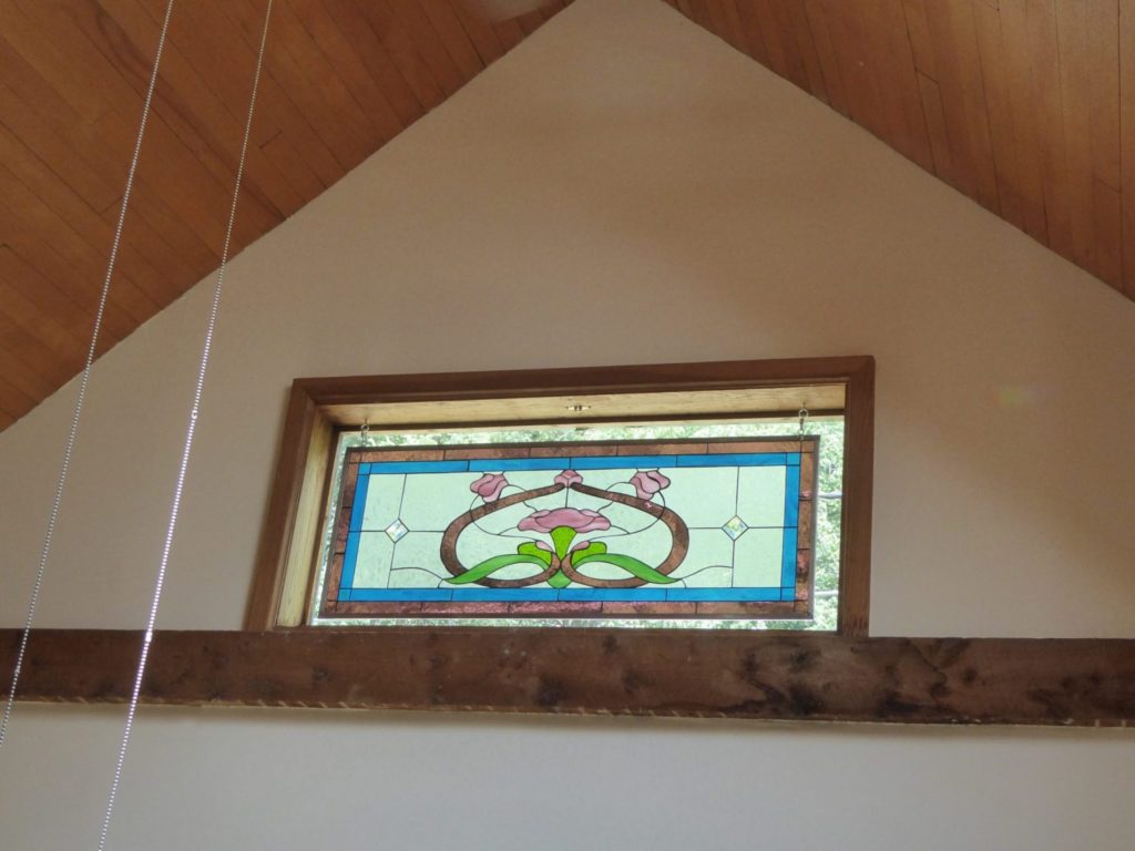 Classic Victorian style stained glass window panel hung with chain