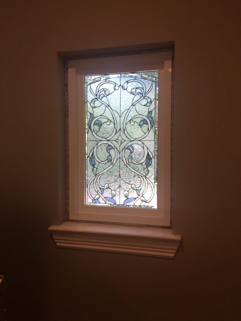 Beveled ribbon & floral window insulated and installed in a vinyl frame
