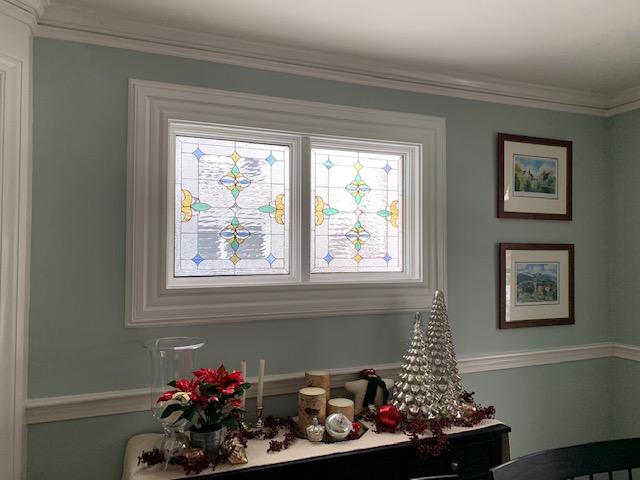 Two Beautiful Pastel Colored Stained Glass Windows Installed In Vinyl Frames In A Dining Room