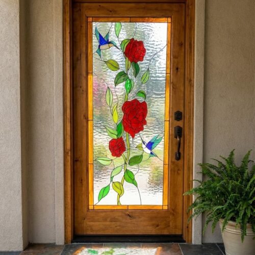A rectangular stained glass door panel featuring a vibrant design of red roses, green leaves, and two blue hummingbirds, set into a wooden entry door.