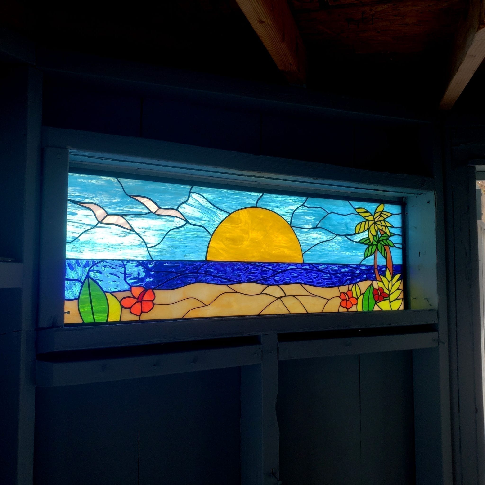 Palm Tree, Flowers & Sunset Stained Glass in front of a swimming pool