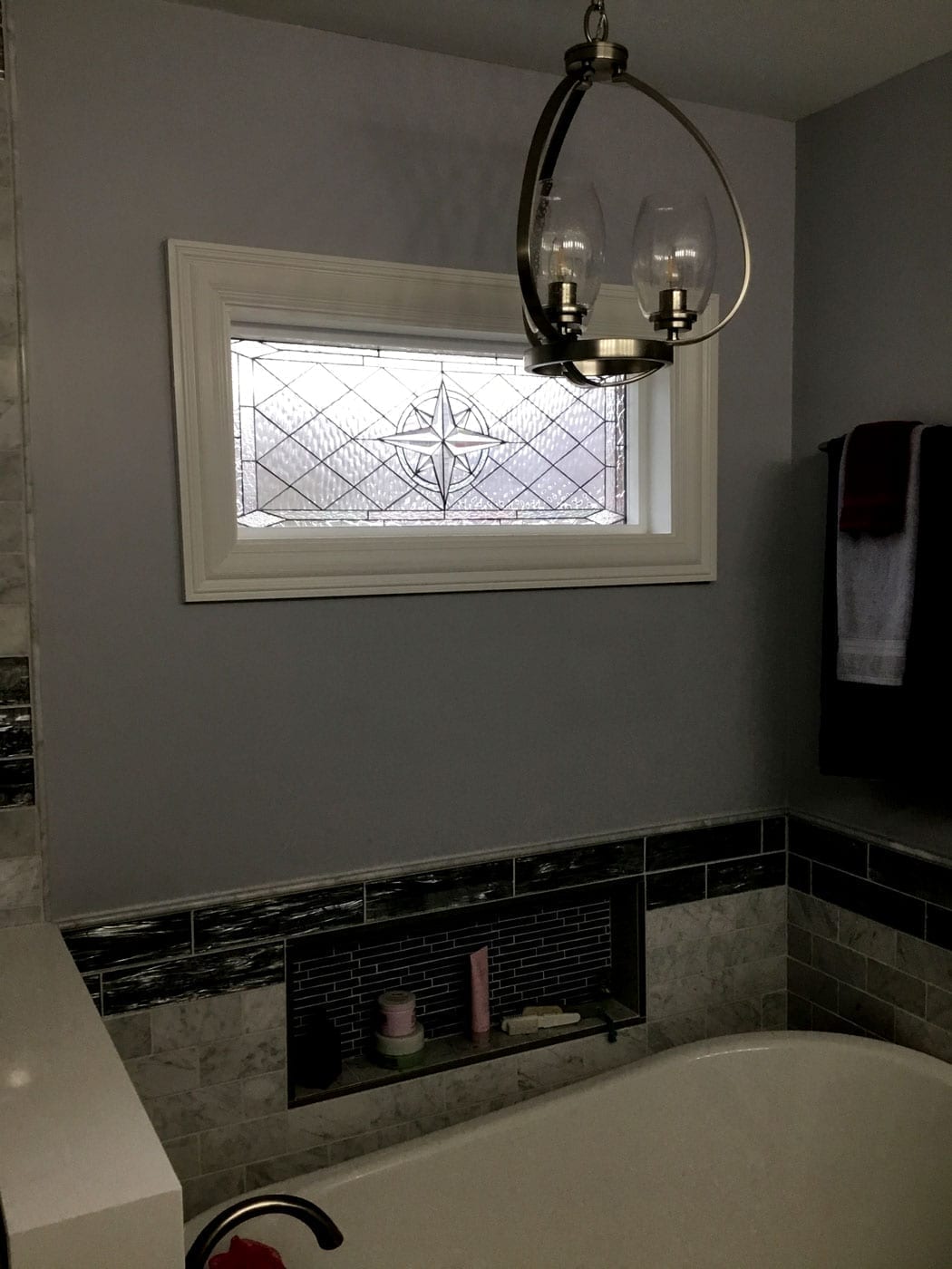 The “Maywood” Stained Glass Window installed over a bathtub