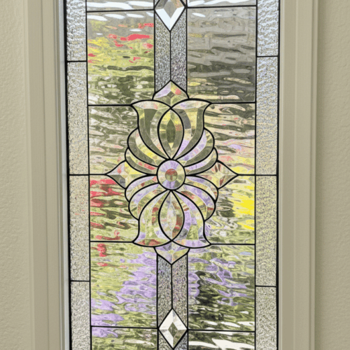 A rectangular stained glass panel with a symmetrical design. The centerpiece is a large, ornate beveled glass cluster, accented by a beveled diamond above and below. The panel is made entirely from clear, textured privacy glass.
