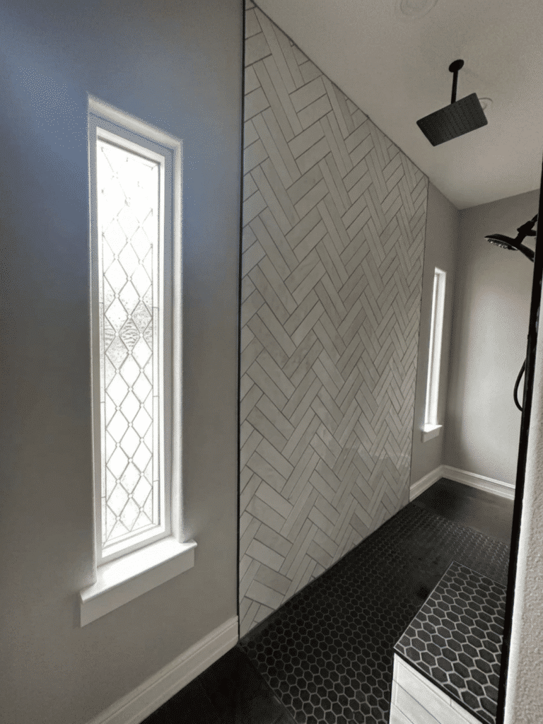 A tall, narrow rectangular clear stained glass window with a repeating diamond and textured glass pattern.