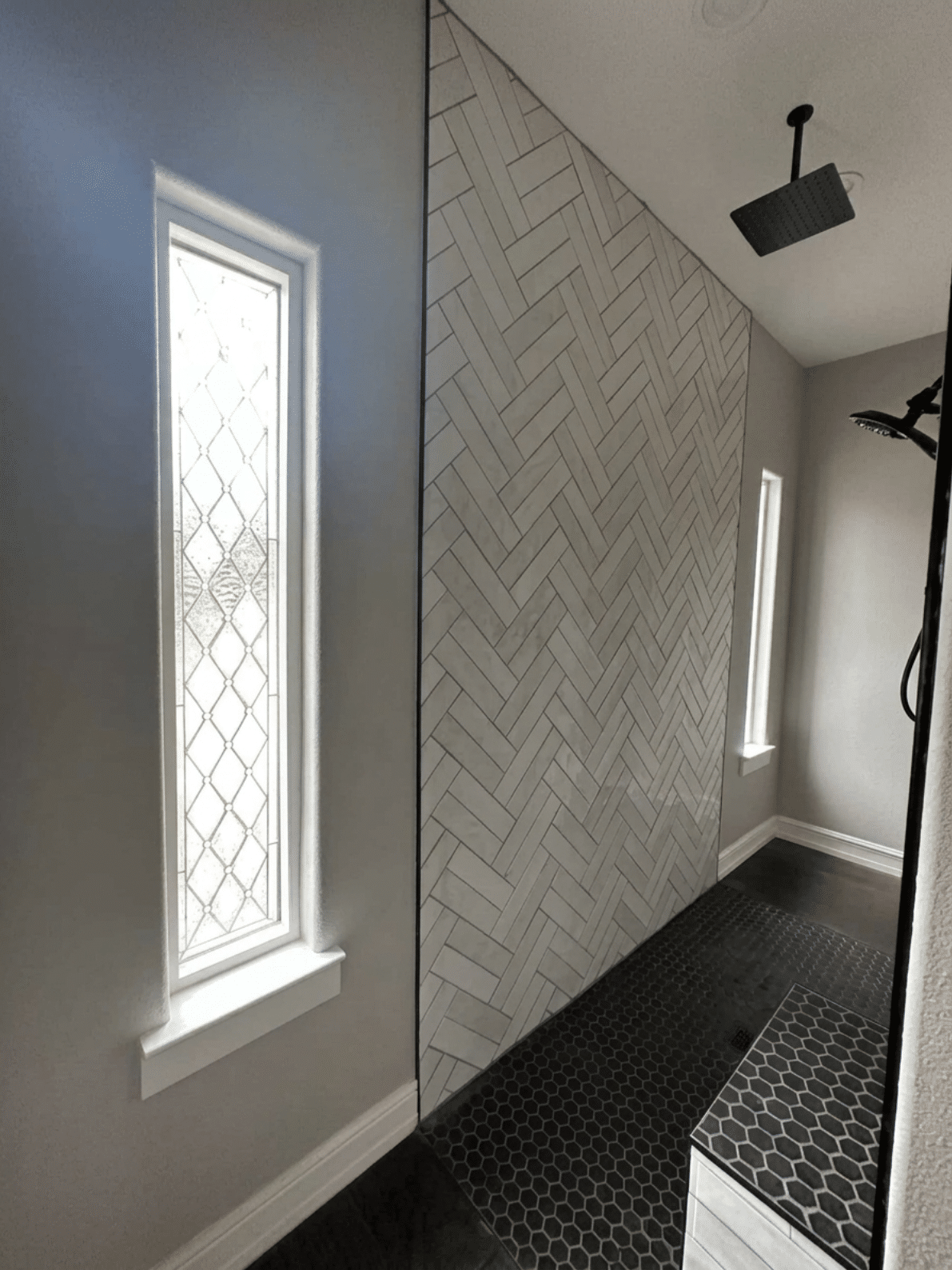 A tall, narrow rectangular clear stained glass window with a repeating diamond and textured glass pattern.