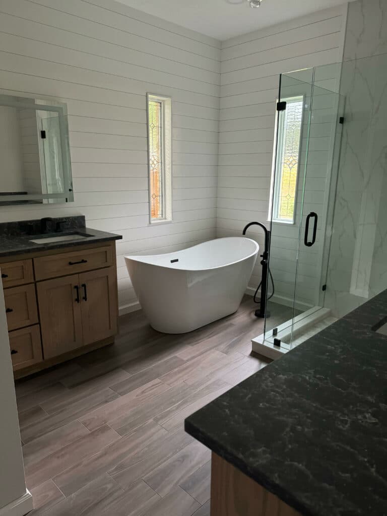 Clear and beveled stained glass windows installed above a bathtub.
