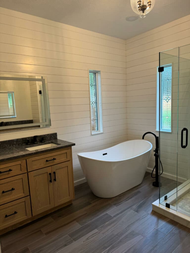 Two tall, narrow clear leaded glass windows featuring textured panels and diamond bevel accents in a modern bathroom.