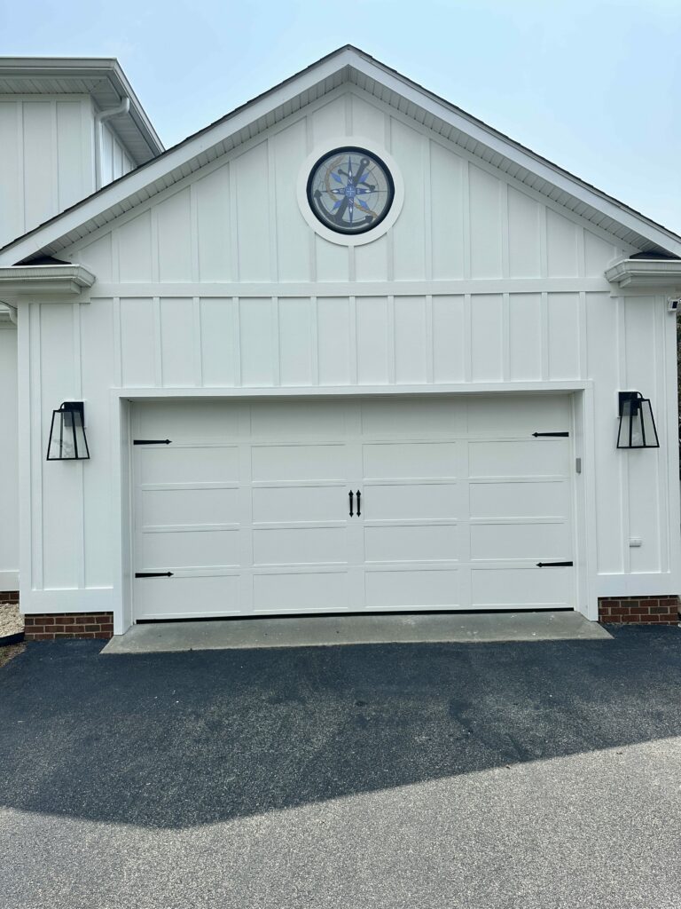 A round stained glass window insert in a white gable features a blue and gray nautical compass rose and anchor design.