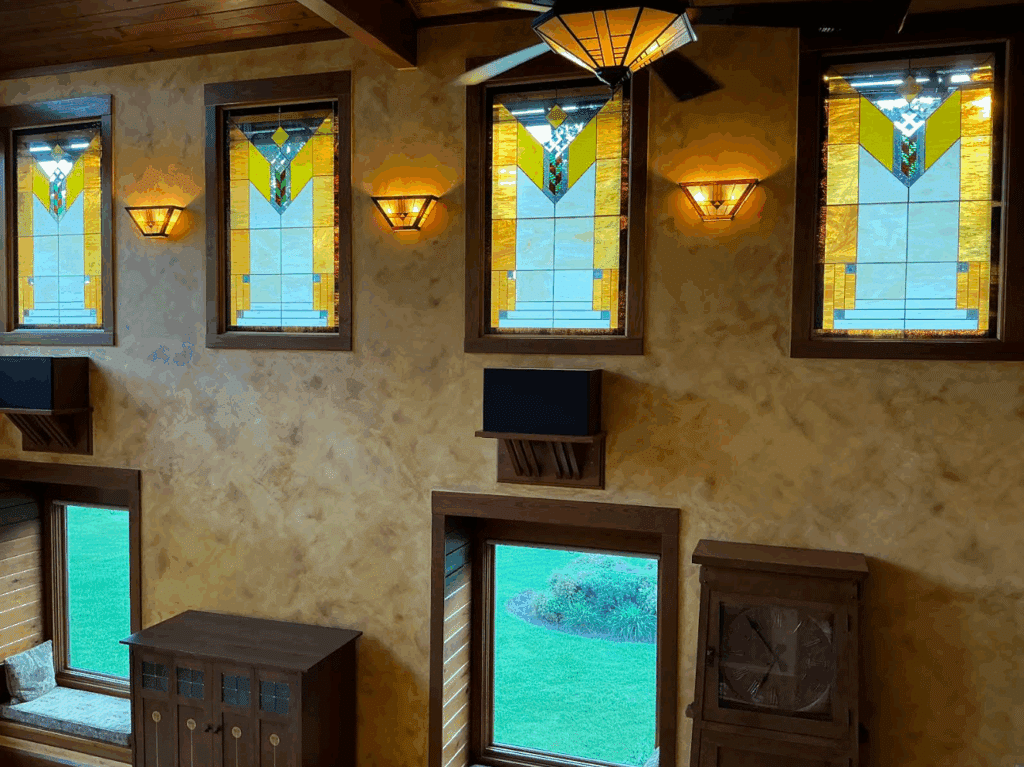 Four rectangular stained glass window panels featuring a repeating geometric Prairie-style design with yellow, clear, blue, and green glass accents.