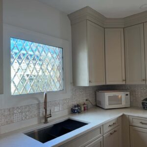 Rectangular Clear Beveled Diamond Pattern Stained Glass Window A rectangular, leaded window featuring clear beveled glass arranged in a diamond pattern, installed in a kitchen above a sink.