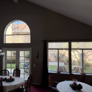 Arched Transom Abstract Stained Glass Panel An arched transom leaded stained glass panel featuring clear textured and beveled glass in an abstract curvilinear design, installed above white French doors.