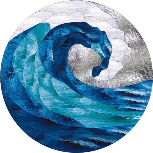 A circular stained glass panel depicting a large, curling ocean wave in varied shades of blue and turquoise, with white and clear textured glass representing sea foam.
